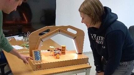 2 Menschen vor einem Licht-Demonstrator