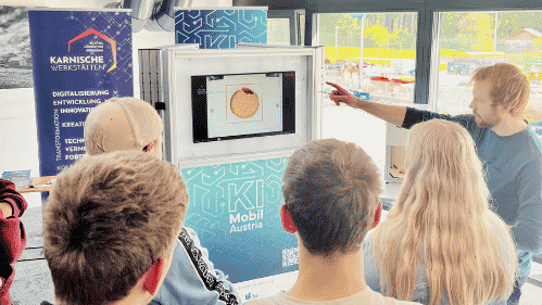Menschen vor dem Monitor des KI-Mobils