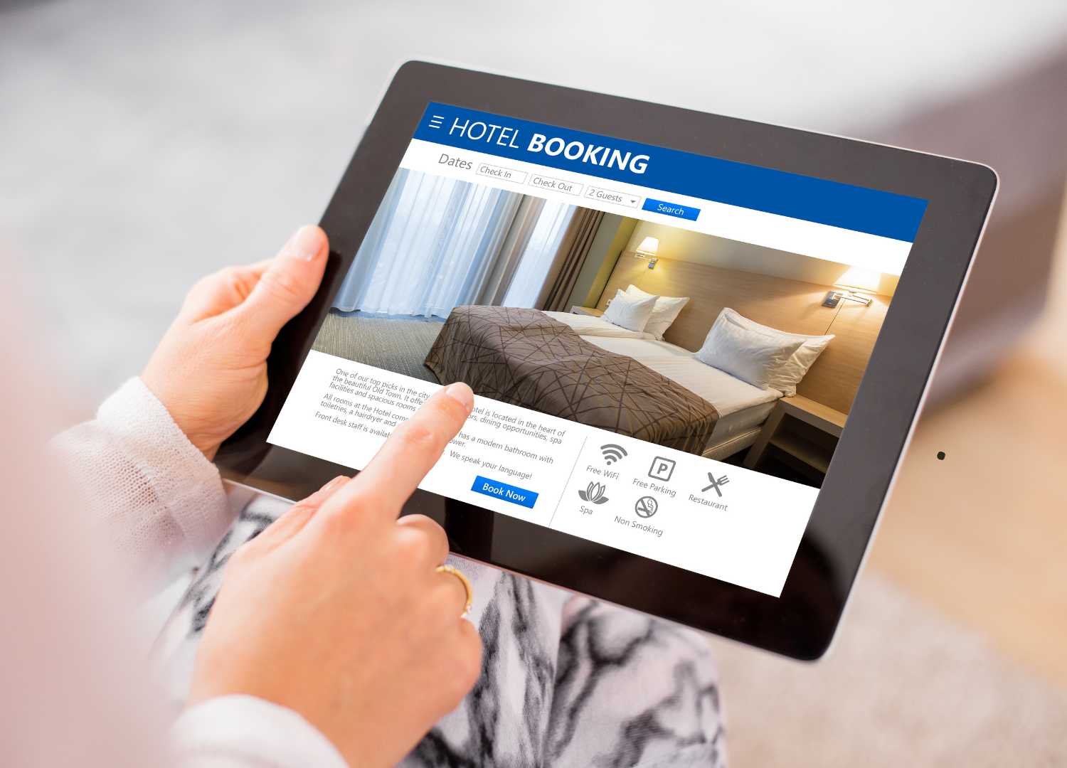 Person bedient ein Tablet mit einer Hotel-App